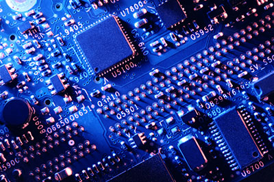 A top view of a blue PCB under red lighting