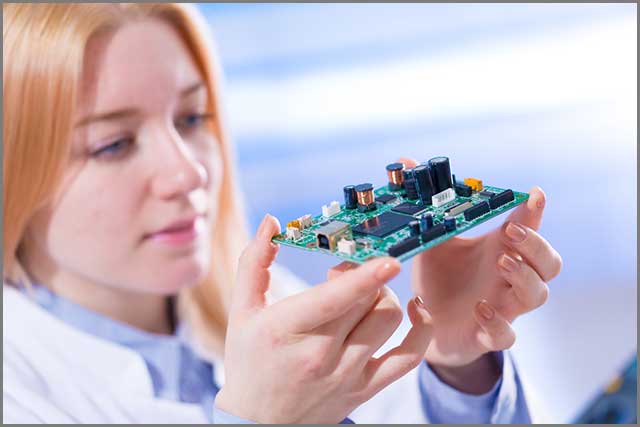A woman holding a printed circuit board