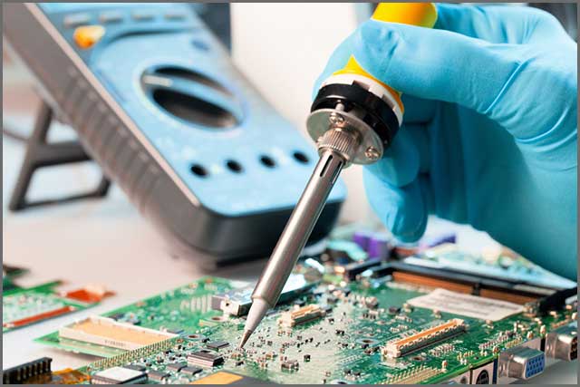 An image of a person soldering a PCB