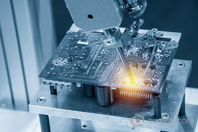 The welding robot solders the circuit board in a light blue scene with lighting effects