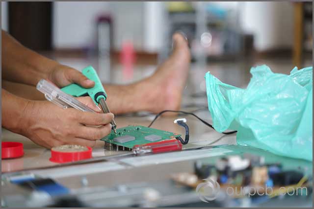 A technician fixing a broken PCB