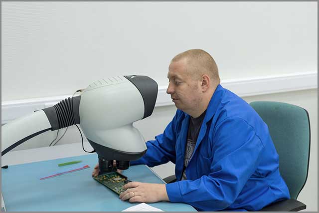 The designer checks the ENIG coating on the flat PCB to ensure proper coating