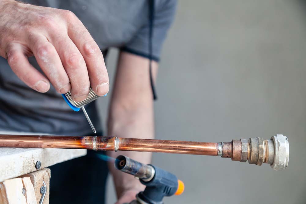 A plumber braze soldering a copper pipe