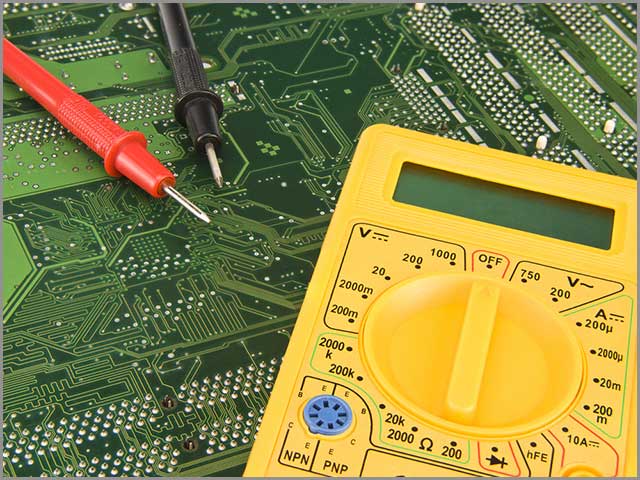 PCB assembly services Yellow multi-meter used to test a PCB before assembly
