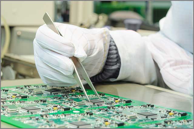 Circuit board maker carrying out quality control procedure on a PCB