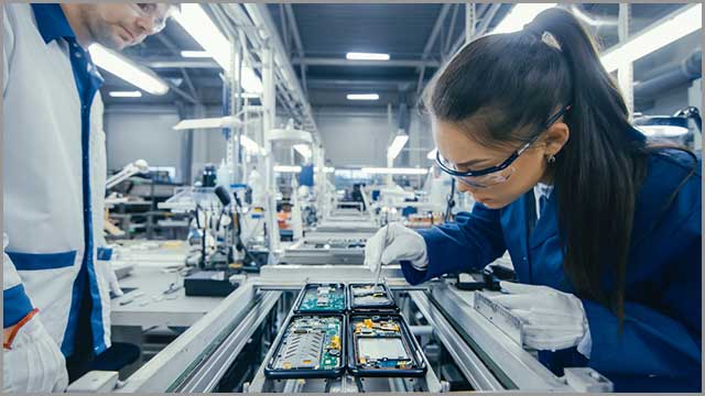 A factory worker assembling a PCB