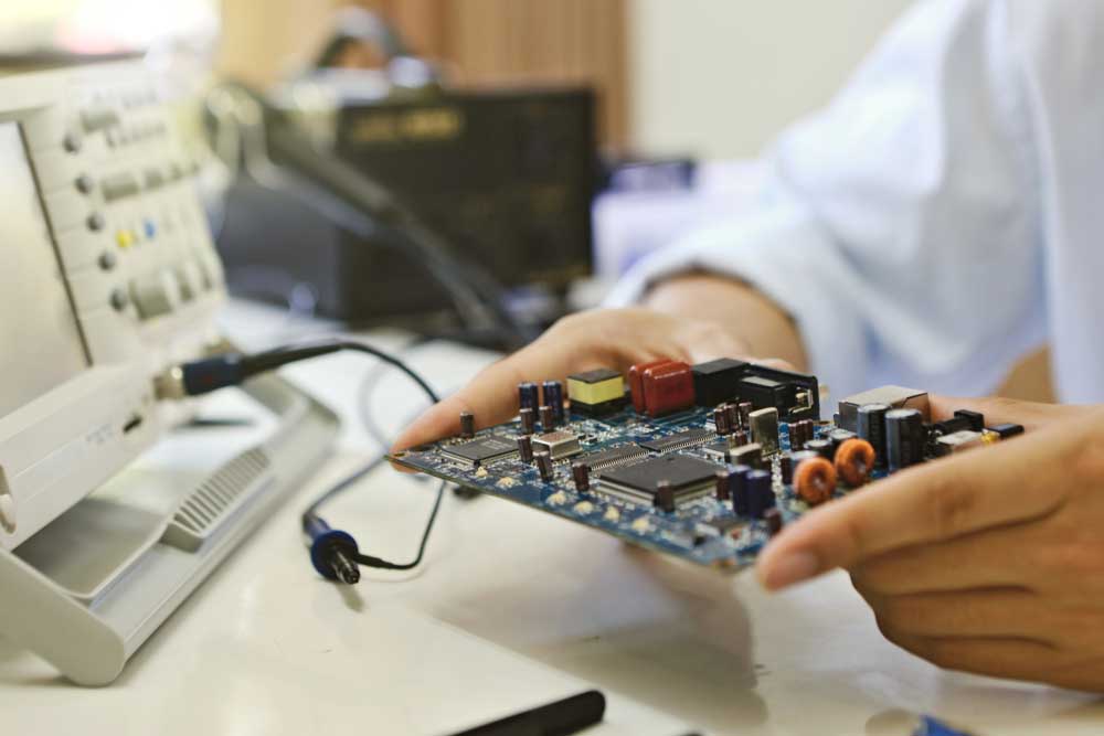 A computer engineer inspecting a PCB using a logic analyzer