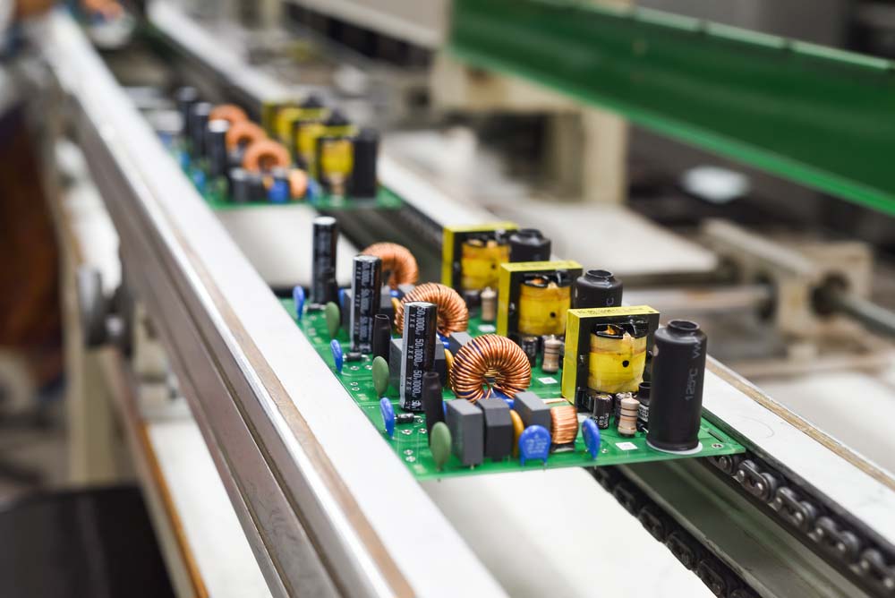 Manual component insertion along a conveyor belt before wave soldering