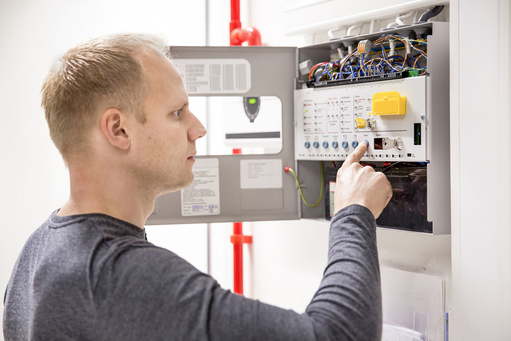 Technician Checking A Fire Panel