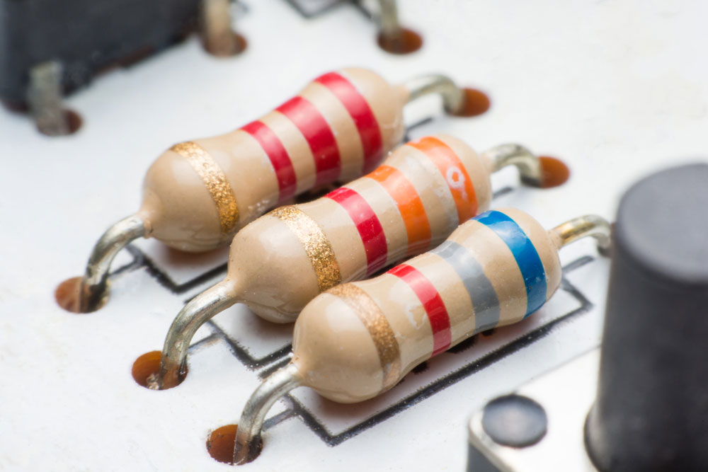 Carbon Film vs. Metal Film:A collection of metal film resistors piled up.