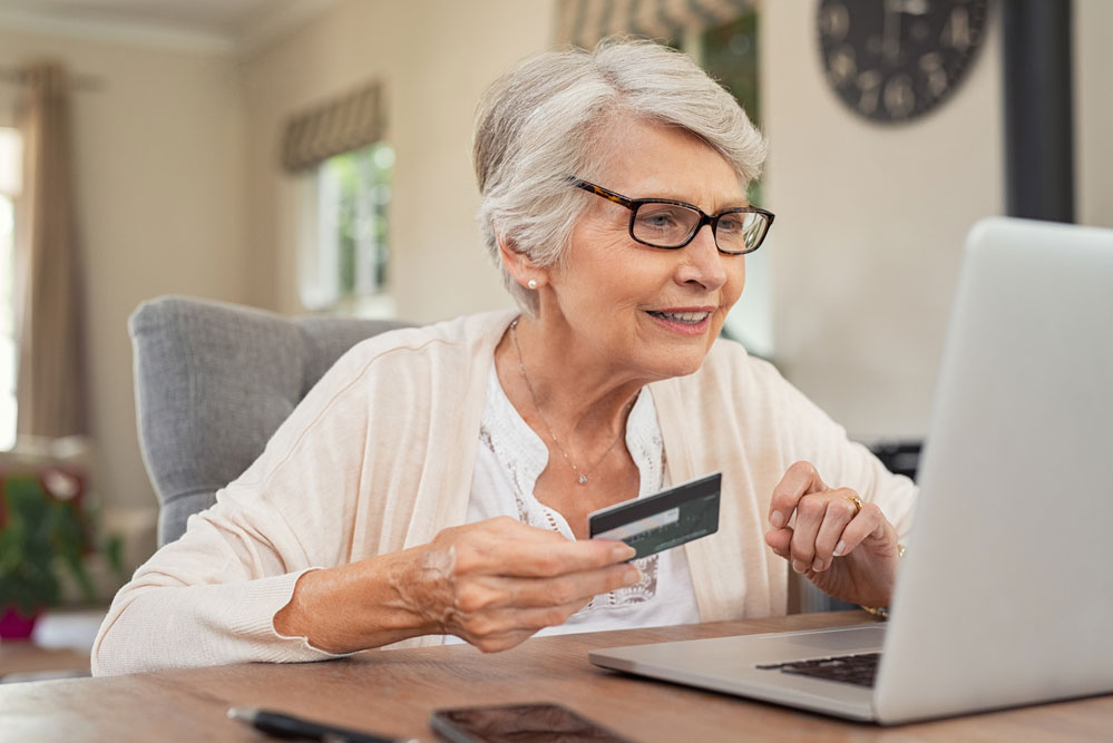Senior woman making payments online with debit card