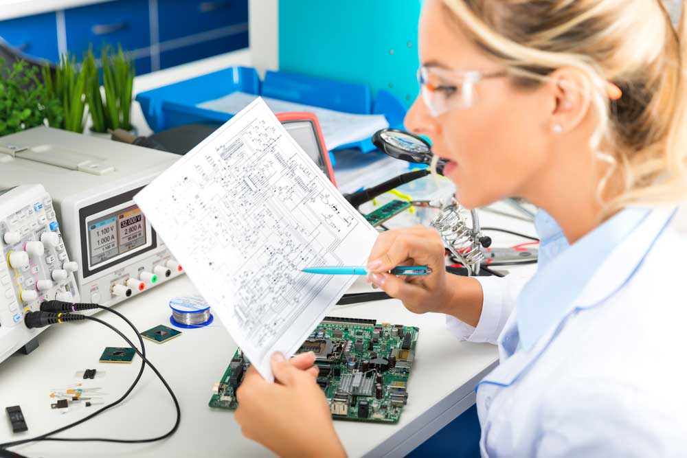 Female engineer checking circuit board design in factory