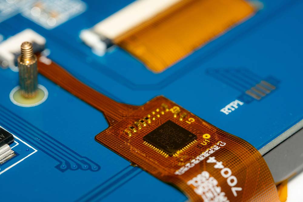 A flexible PCB with a chip and some components soldered onboard
