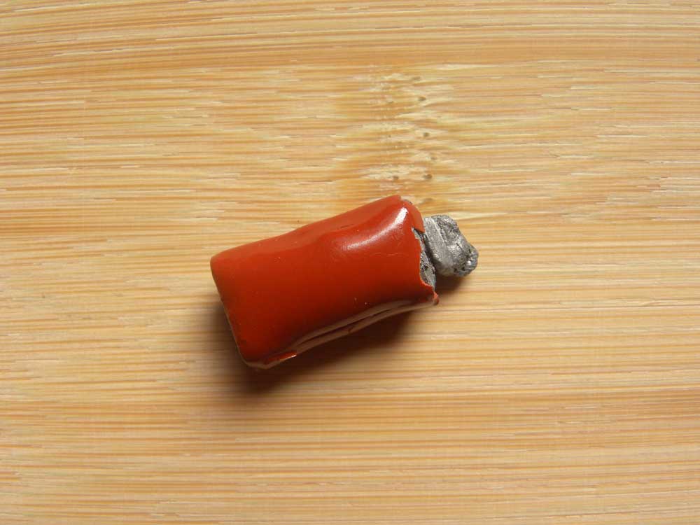 Damaged red ceramic capacitor