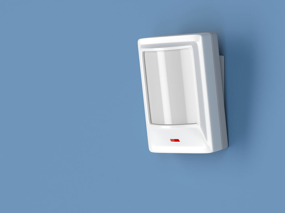 Motion detector attached on a blue wall