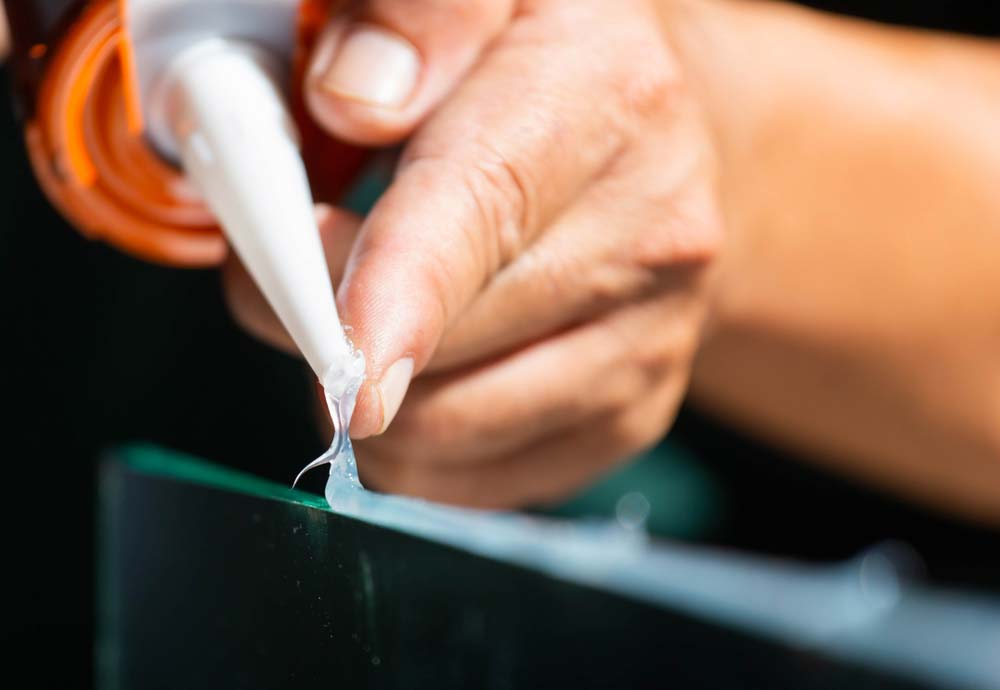 A silicone glue gun dispensing clear silicone adhesive