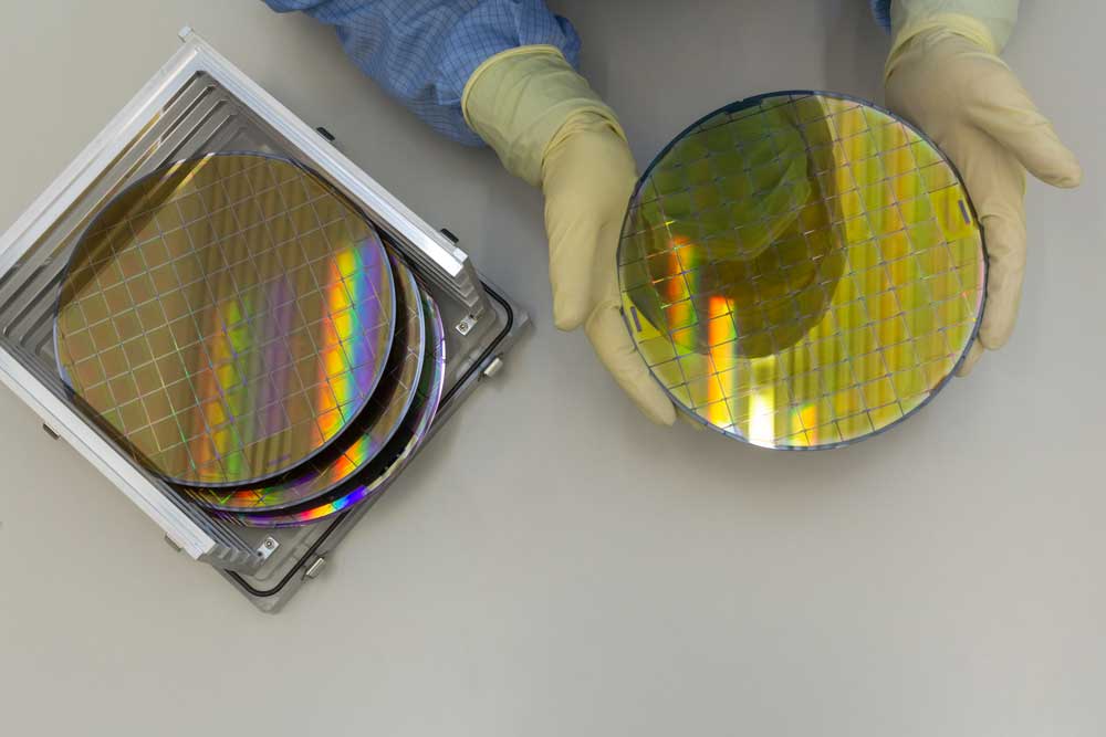 A worker holding silicon wafers