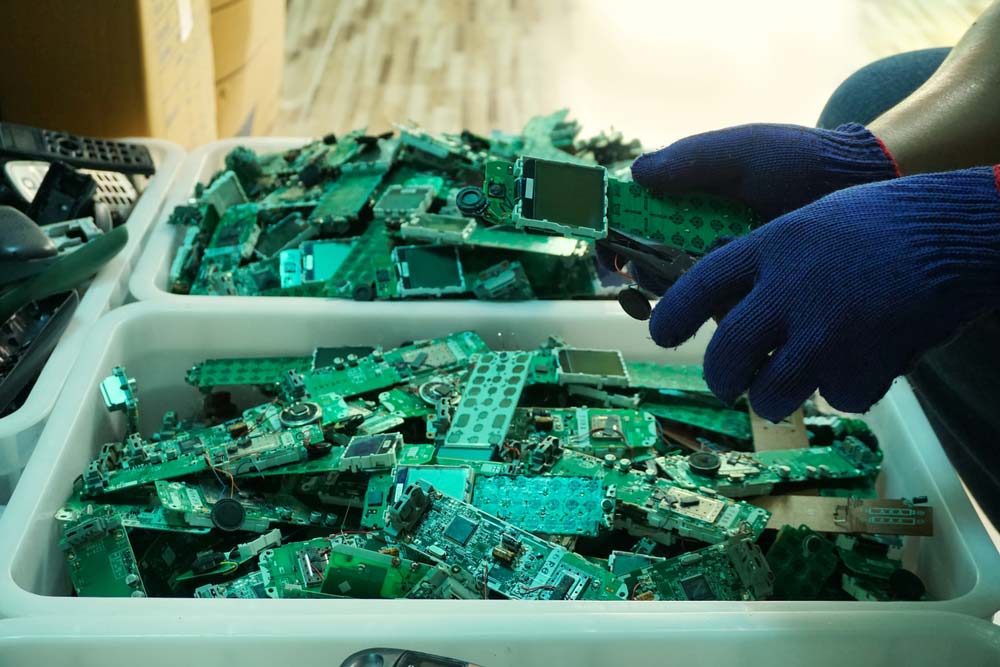 Phone PCBAs being disassembled in a recycling plant