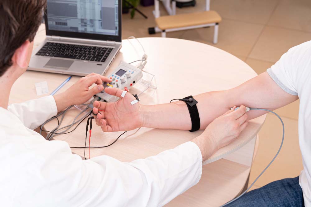 A medical professional examining EMG data using software installed on a laptop