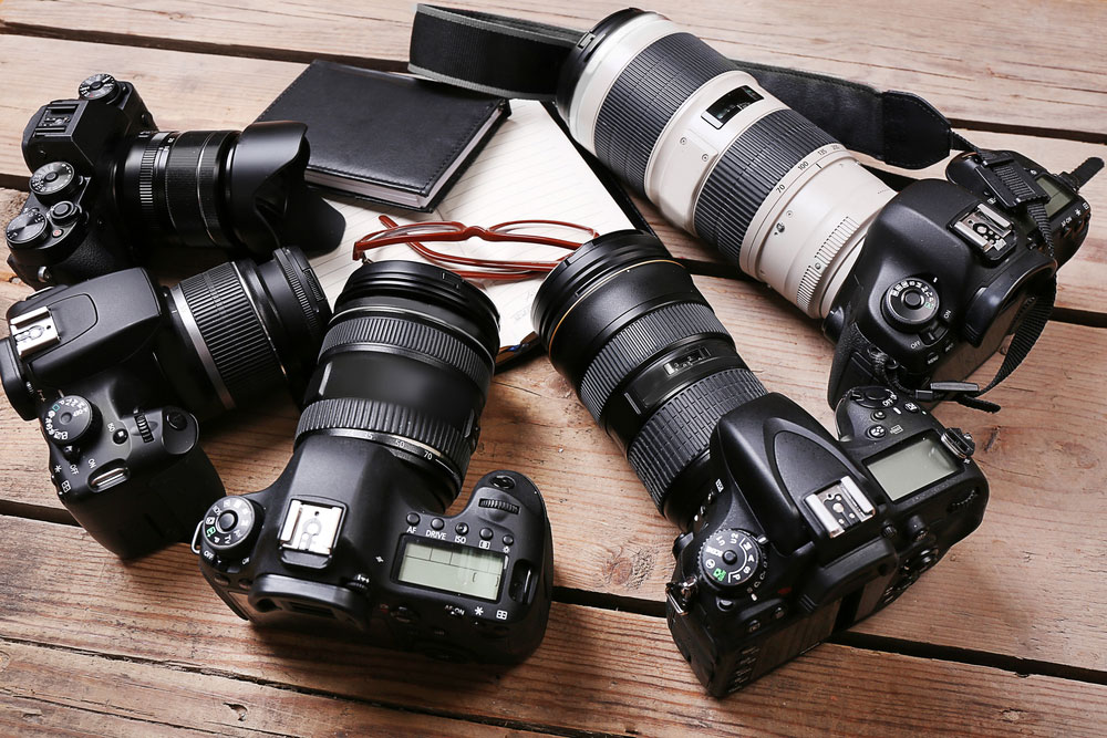 Modern cameras on the wooden table