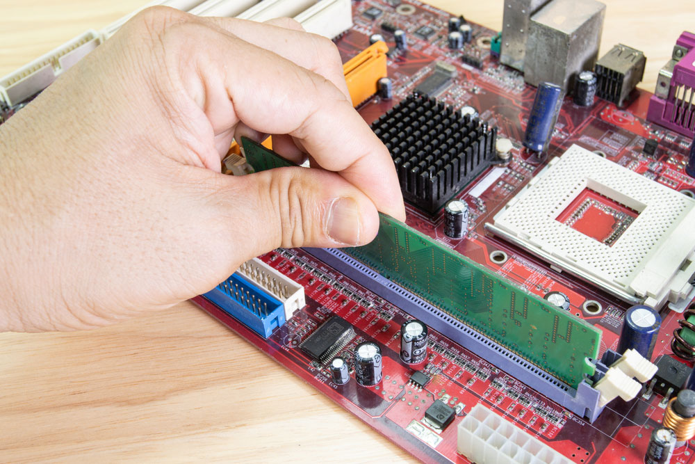 The technician is installing RAM on the motherboard Computer.     