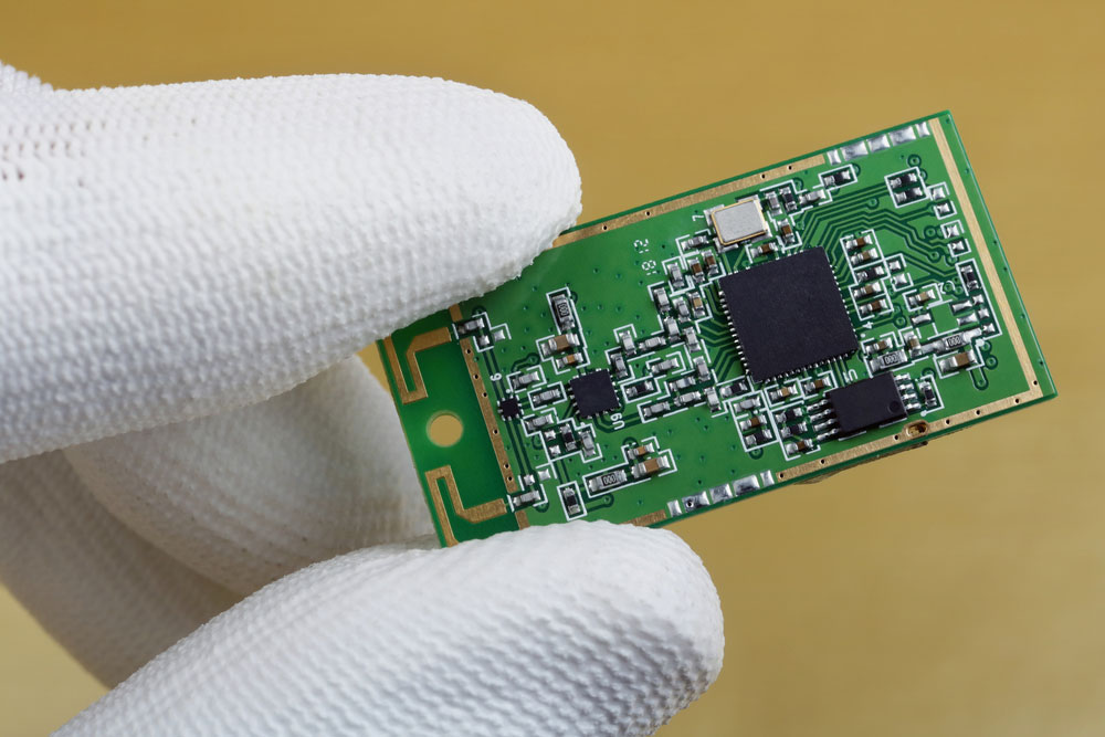 A technician controls the quality of a mini wireless Bluetooth module