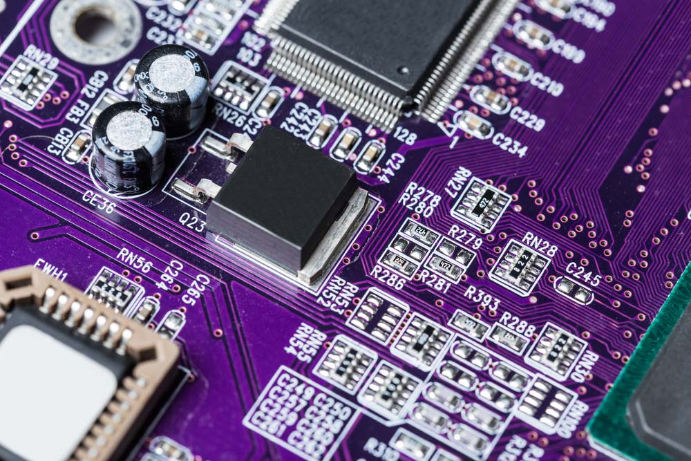 An assembled purple PCB with white silkscreen markings