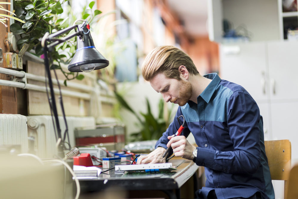 A man working with a soldering iron