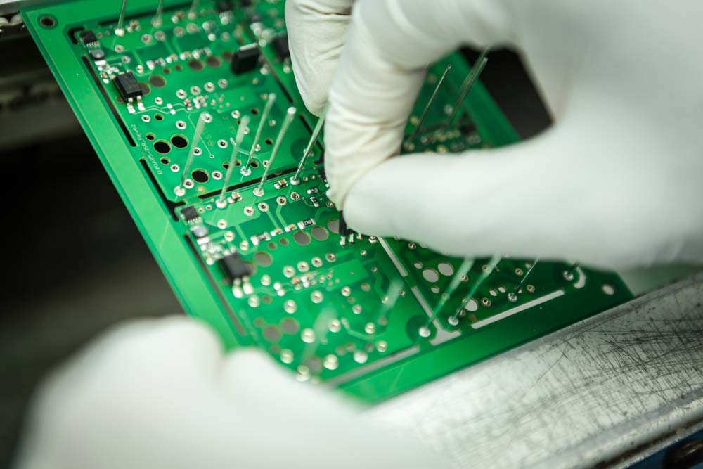 Electronic component assembly on panelized green PCBs