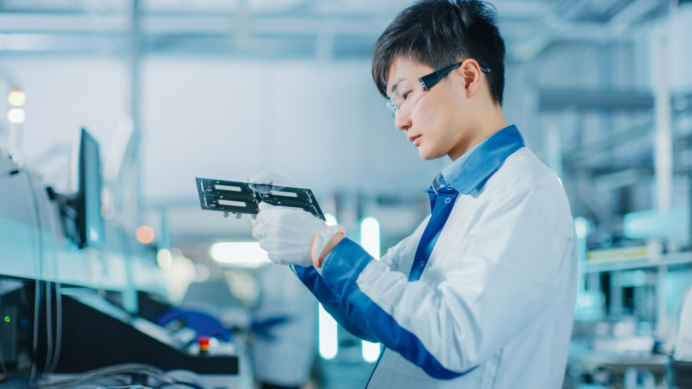 An SMT operator programming the machine using a computer