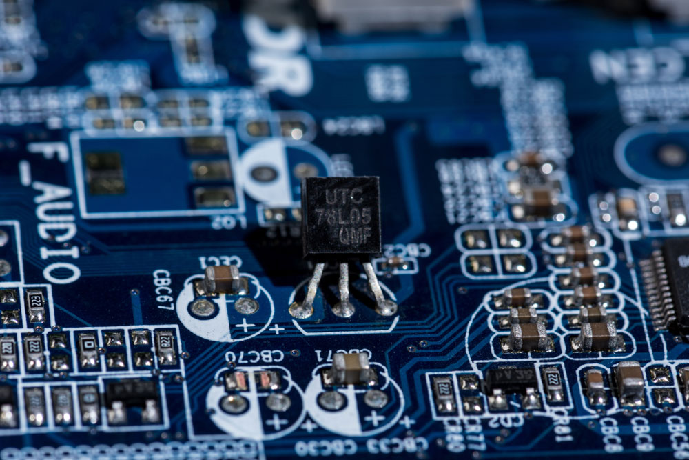 Several SMT components and one through-hole component are soldered on a PCB. Note the size difference.