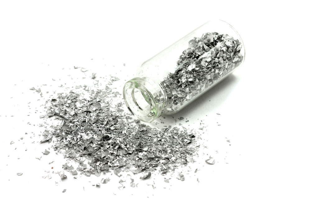 Silver metal granules in a glass flask. The nanoparticle powder must have smaller particles.