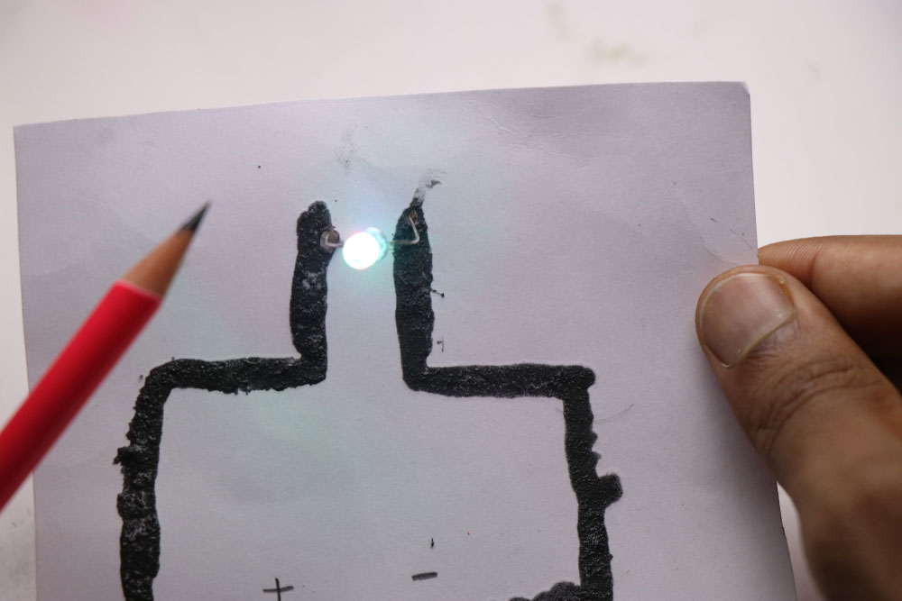 Conductive ink from a pencil’s graphite lighting an LED