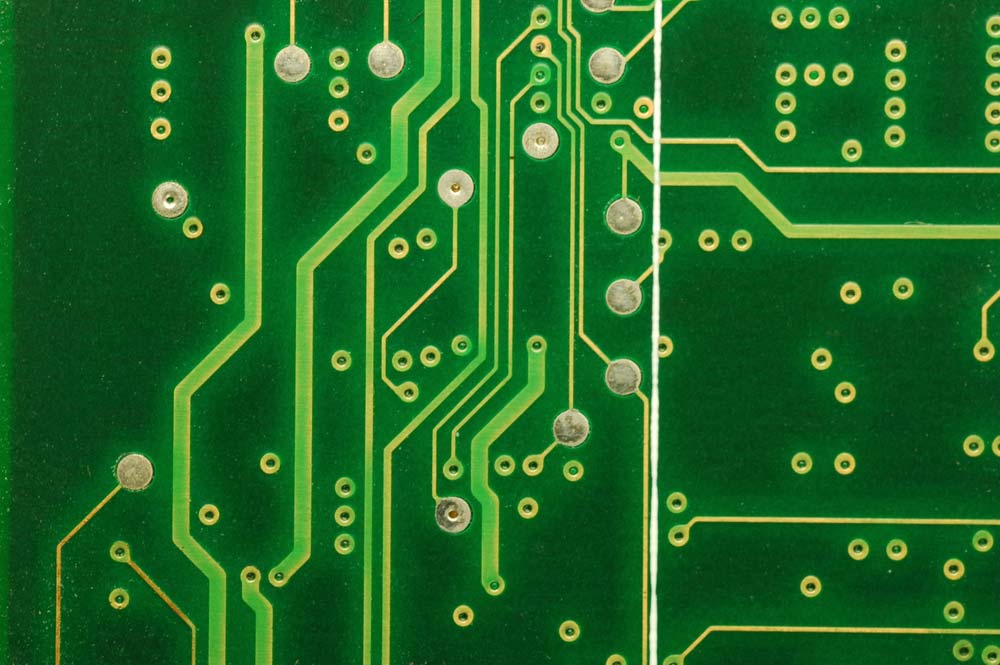 Copper traces and holes (vias) on a blank printed circuit board.