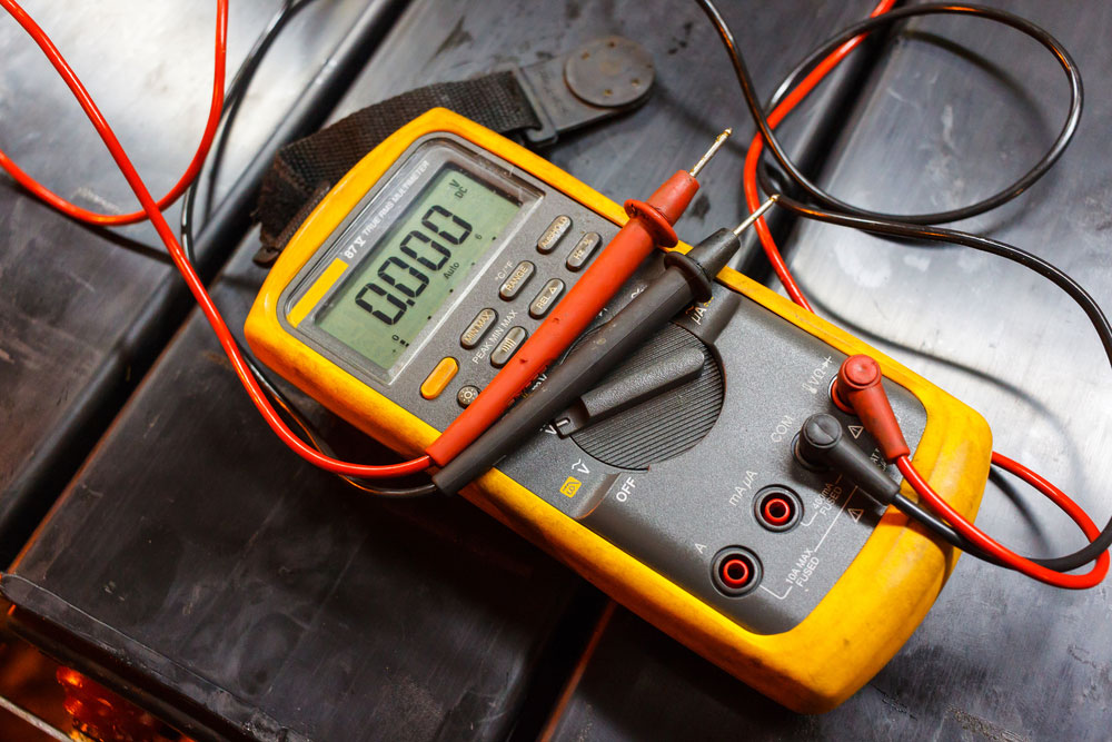 A digital multimeter with red and black probes connected