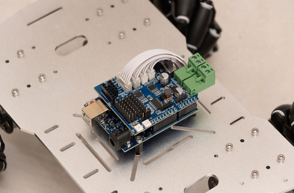 A development board with an expansion shield for connecting a radio transmitter, stepper motor, and servo motor