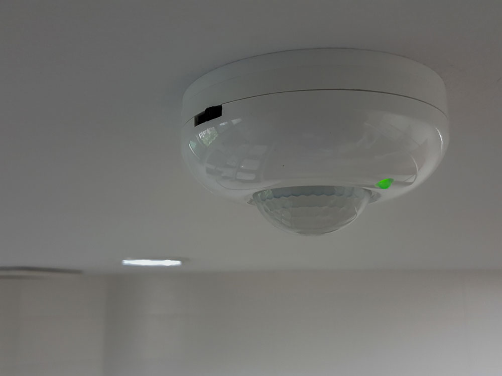 An infrared motion sensor is mounted on the ceiling.