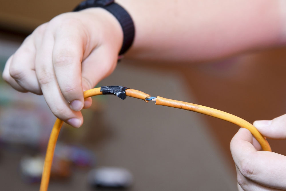 An electrician holding a section of a nicked wire