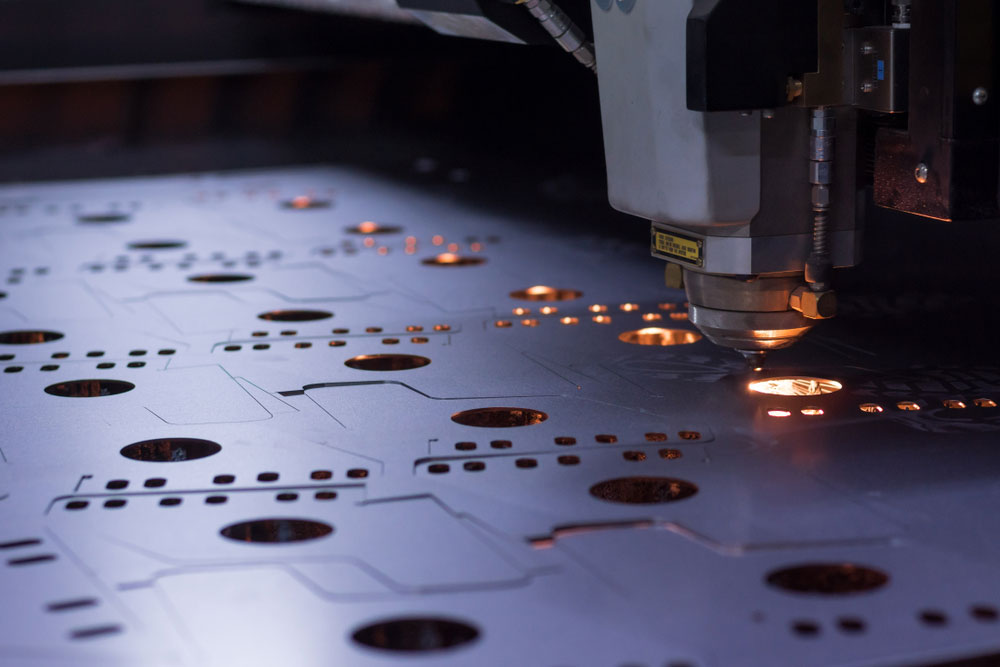 A CNC laser cutter machining a metal sheet