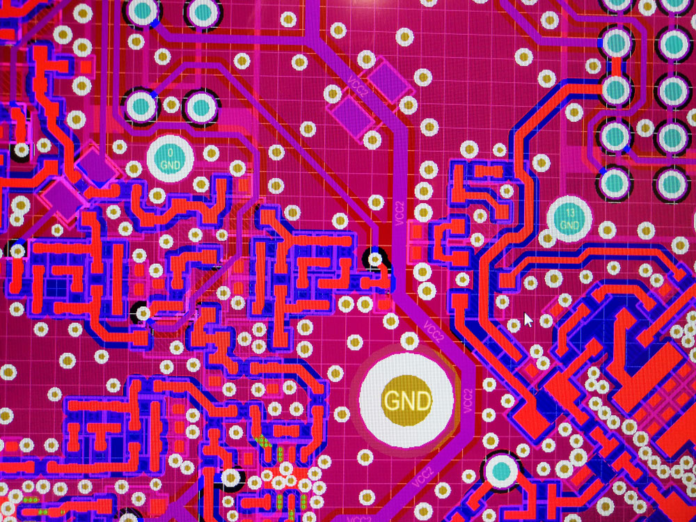A close-up of the PCB design layout routing process using CAD software. Note the ground thru holes