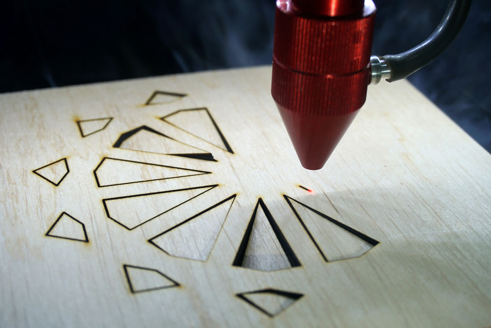A laser cutter cutting plywood