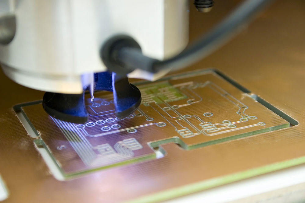 An up-close image of a milling machine cutting a circuit board