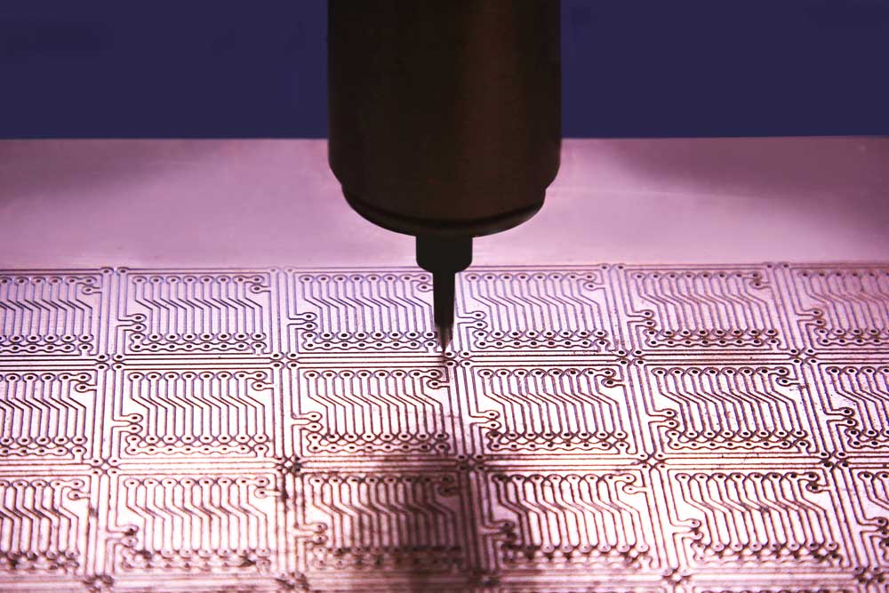 A drillbit drilling holes through a PCB for mounting chips