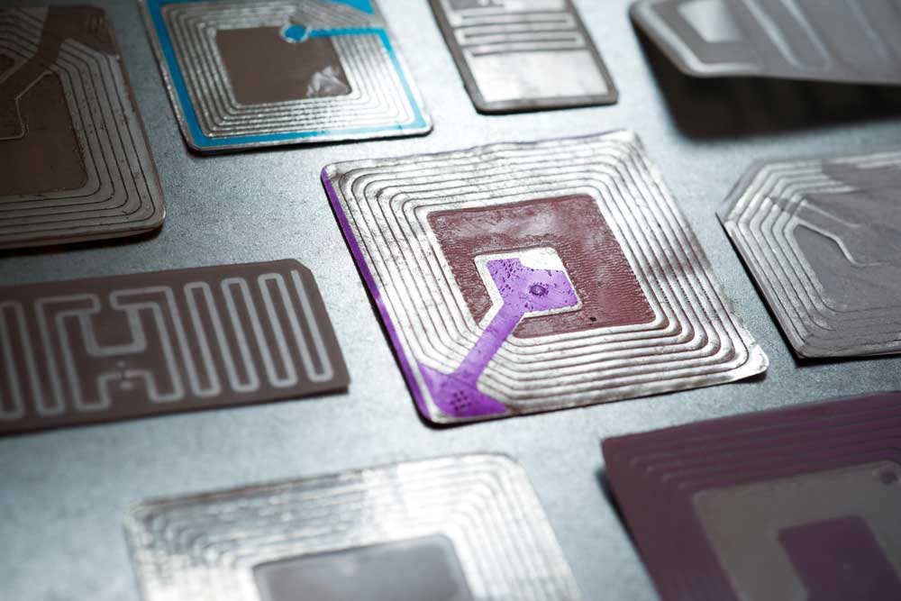 A circuit board serial number lookup process is essential for traceability and repairs. Printed circuit boards undergo complex manufacturing and assembly processes, so they must have labels to help identify where each board passed through and the components it has. Labels contain critical data, one among them being the PCB serial number. Let’s look at the importance of this label and the serial number written on that sticker, plus the PCB serial number lookup process. What Is a PCB Label? A board label is a sticker with information for tracking the electrical components used on PCBs during production, storage, and installation. These labels contain the following information. Serial number Model number Assembly number Lot number Soldering temperature Flux density Test data https://www.shutterstock.com/image-photo/electronics-manufacturing-services-assembly-circuit-board-1510508564 Multiple PCB assemblies in storage Labeling ensures the boards get the correct and required components. Manufacturers use this PCB identification data to trace the pieces for recalls if they realize there were errors during manufacturing or storage. Although uncommon, errors can occur, especially when dealing with tiny parts. So, board labels help keep track of the production and storage parameters to enhance production efficiency. Most manufacturers use polyimide labels because they withstand the heat in reflow ovens. What Is a PCB Serial Number? PCB serial numbers are part of the label and are responsible for tracing the parts or components soldered on the board for modifications or repairs in the event of failure. It is uncommon to find PCBs with standardized electrical components that don’t change over long manufacturing periods. Remember, these electronic components receive updates (improved product versions) with better performance or lower power consumption. https://www.shutterstock.com/image-photo/soldering-iron-tips-automated-manufacturing-assembly-1065643667 Soldering iron tips for automated component soldering during assembly Also, some circuit boards get manufactured or assembled over months or years. The manufacturer or assembler can change the design or parts during this period. Serial numbers help identify the electronic components used on individual boards during assembly to ensure accurate repairs or modifications. Circuit Board Serial Number Lookup Process This process involves finding the serial number on the board, which you can use to find the specific board components from the manufacturer. Sometimes, this code is not easily accessible, so use either of these methods to locate the serial number. Method 1: Lookup the Part Number Most circuit boards have two part numbers printed on the surface. The first gives the PCB an identity when it is bare with no electronic devices, and the second identifies the board when it has all the electronic components soldered on the surface or through holes. https://www.shutterstock.com/image-photo/green-printed-circuit-layout-tracks-2163675667 An unassembled circuit board with a layout of copper tracks Look for this second part number because we want to know the parts soldered on the bare board. Some PCB assemblers label it CCA (Circuit Card Assembly) to give it a unique identity from the unassembled board part number. The board’s serial number should be near the CCA as a handwritten or ink-stamped short hexadecimal or alphanumeric number. However, some manufacturers can use bar codes instead of numbers to indicate the part and serial numbers. Method 2: Lookup the Part Number in the Ground Plane or Large Wiring Trace Some manufacturers etch the part number on a solder-coated copper ground plane or broad wiring trace. This section usually also has the manufacturer logo, patent number, and CCA number etching. You should be able to locate the serial number near the CCA as a handwritten number next to the letters S/N or SN. It can also be on tiny labels placed near the CCA. And like the method above, some boards have the part and serial numbers as bar codes. You might need a magnification glass for methods one and two if the board has numbers instead of barcodes to avoid confusing 0, 3, and 8. Reading this label is more challenging if the number size is tiny and ink-smudged. Method 3: Use a Serial Data Communication Program All PCBs have a memory chip to load the software or firmware to run the hardware, and manufacturers store the board’s serial number in this integrated circuit. Some professional repair facilities have the equipment and software to extract serial number data from this board memory. For instance, automated test equipment with software like Winviews uses subroutines to access the following. CCA identification & modification status Serial number Individual microcircuit identification These subroutines are like command line queries. An example is “PS” in WinViews, which returns the board’s current status. This status includes the modification status and serial number, among many others. Are Barcodes Better Than Written Serial Numbers? Barcodes usually encode the time and location of the board’s manufacturing, solder temperature, flux density, test data, and electronic component numbers. They can store even more information if you use them with automatic identification systems. So you can have all the board’s identification data in a tiny space. But there are some downsides. For instance, the automatic identification system or reader requires a direct line of sight to the label. This arrangement limits the amount of data the electronic system can encode. https://www.shutterstock.com/image-vector/bar-code-pcblayout-style-vector-illustration-199212626 A barcode in a PCB layout style 2D barcodes are slightly better, but their readers are costly and feature limited accuracy. And high-component-population boards might lack enough space to stick one bar code. Machine vision systems like optical character recognition and verification take barcode technology up a notch because they can identify PCBs and high-value components. Therefore, they are better than written serial numbers but have challenges that make them unideal for modern PCBs. RFID Chips for Serial Numbers This chip technology is better than barcodes because it holds all the PCB’s identification data on the board; you can mount it as a surface-mount component. https://www.shutterstock.com/image-vector/barcode-rfid-chip-603344924 A barcode placed above an RFID chip Plus, you can update data on the chip at any step in the manufacturing, assembly, shipping, or repair processes. Some benefits of this setup include: Automated traceability Real-time alerts during production Quick defective component isolation Integrated authenticity Fast shipping-receiving reconciliation Ready delivery capability assessment Connects manufacturing visibility and supply chains https://www.shutterstock.com/image-photo/rfid-tags-on-metal-table-2006394536 Multiple RFID tags The most significant advantage of this board identification chip is it is an off-the-shelf solution that provides real-time board visibility. Wrap Up As you can see, including serial numbers in PCBs is critical for their manufacturing and repair processes. And the technology keeps evolving to make tracking and traceability easier. RFID chips currently offer the best solution because they mount the board’s data directly on the board. Plus, they are easy to update and provide real-time alerts during production. Therefore, they hold the most up-to-date data that makes repairs more accurate. That marks the end of this article. Contact us if you need a PCB with this ID tracking technology for your project, and we’ll reach out to discuss the details. 