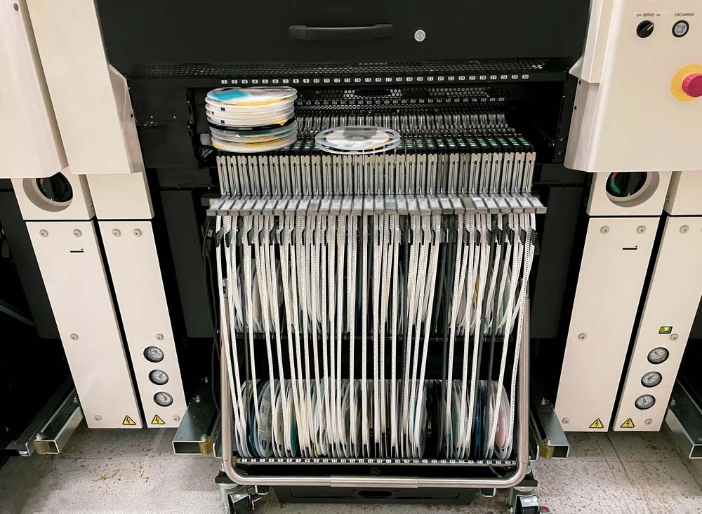 Surface-mount component reels feeding a pick-and-place machine during SMT assembly